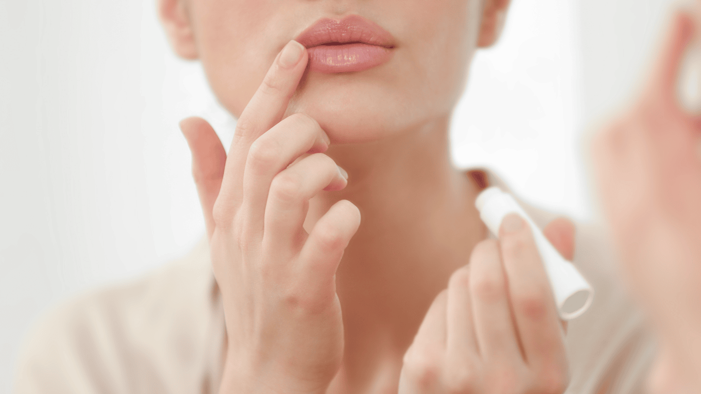 Mujer poniendose bálsamo de labios (cacao) en los labios
