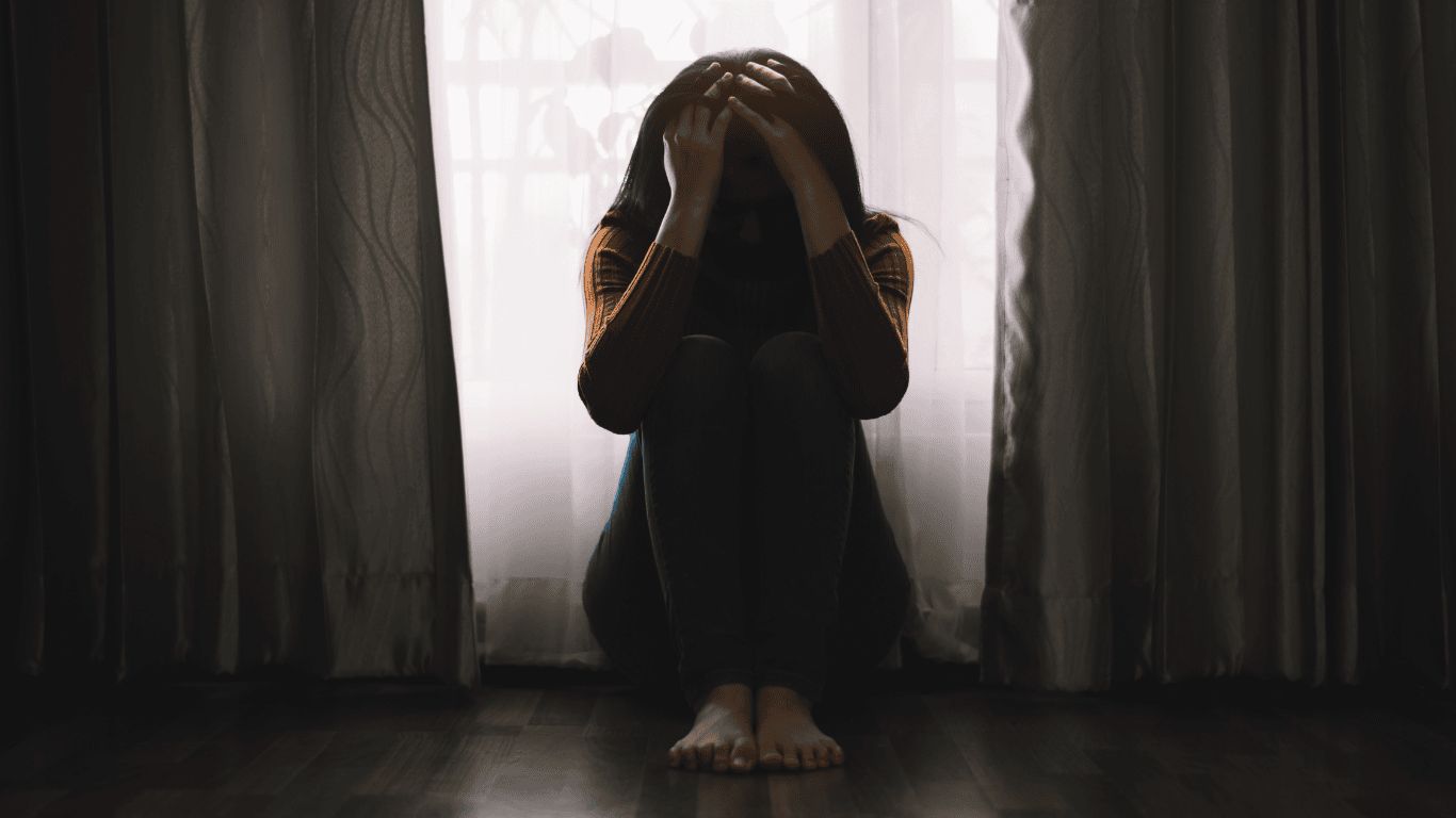 mujer sentada en el suelo con ansiedad otoñal